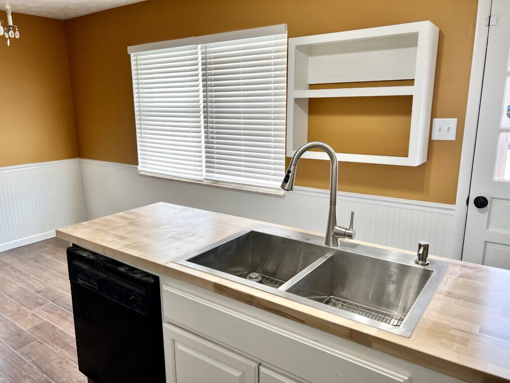 Mustard yellow kitchen with sink and new butcher block