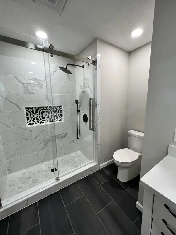 Marble tile shower with decorative tile inset