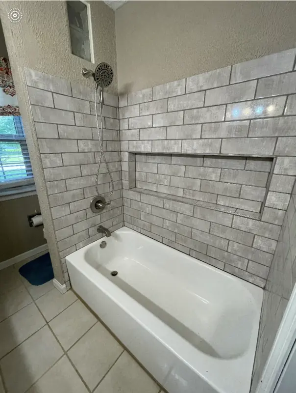 Neutral grey subway tile shower with built-in shelf